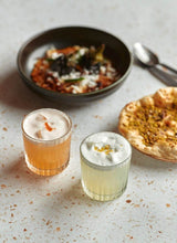 Load image into Gallery viewer, Two Sollasa cocktails with some Indian dishes
